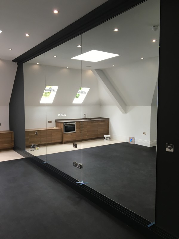 Frameless glass partition in loft conversion by Archway glaziers