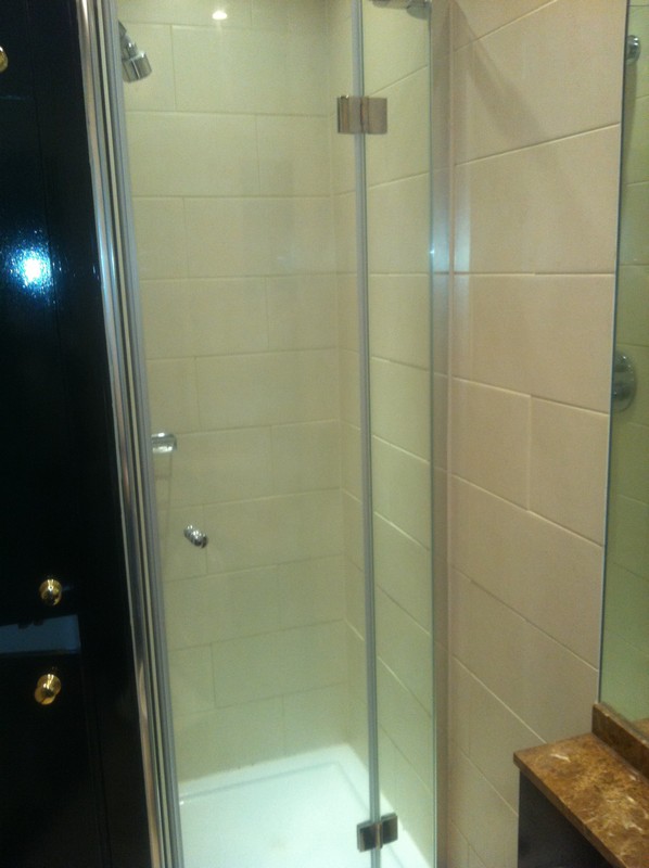 Frameless glass shower enclosure with chrome fittings in Archway